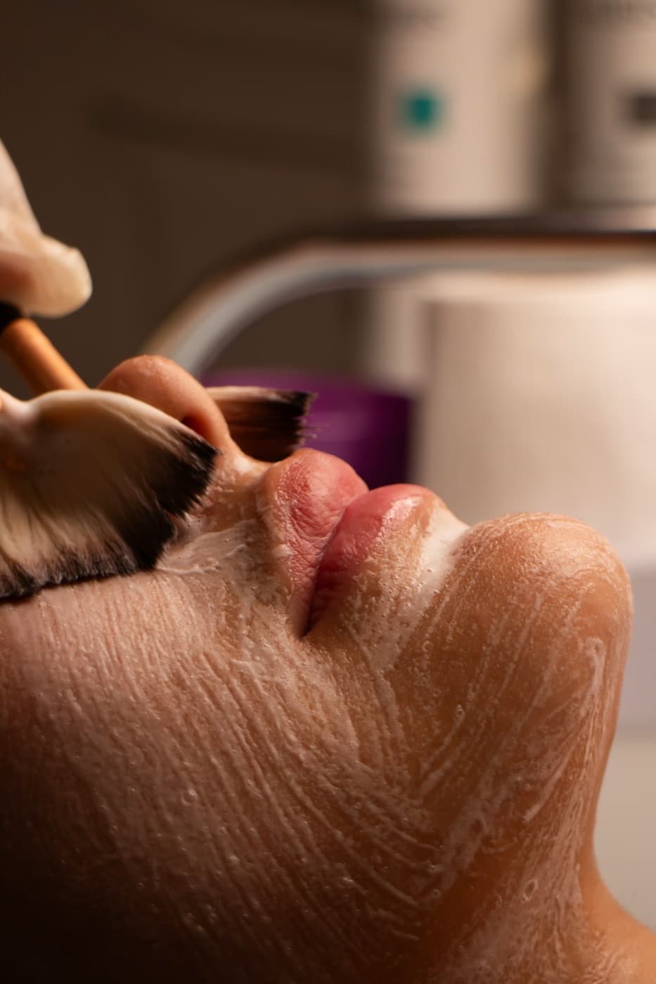 A fan brush applying a treatment enzyme during a facial